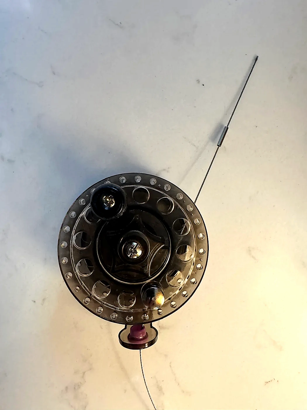 Stainless-steel counterpoise wire attached to a compact fly-fishing reel with a crimp sleeve ready on the free end