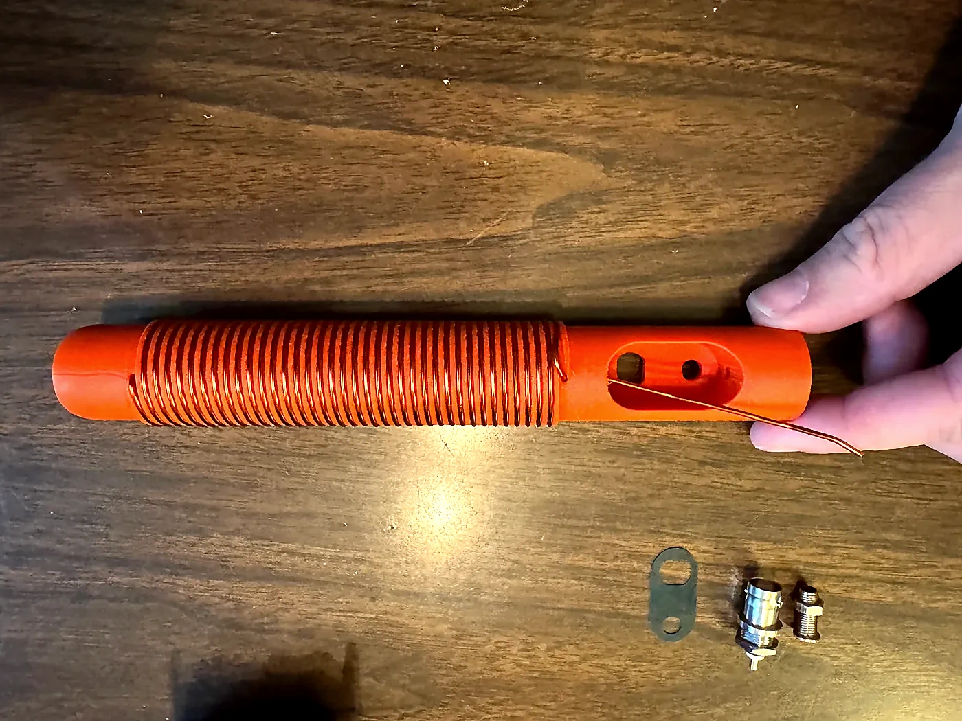 Copper magnet wire wound around the full length of the orange Hamdo coil form